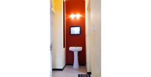 La salle de bains est pourvue de toilettes et d'une télévision murale. dans l'établissement KP Holidays తెలుగు Cottage, à Ooty 20 autres photos