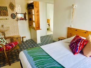 a bedroom with a bed and a chair at Coco bay 2 in Saint-Benoît-des-Ondes