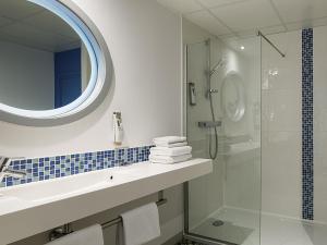 une salle de bain avec un lavabo et une douche en verre dans l'établissement ibis Styles Strasbourg Avenue du Rhin, à Strasbourg