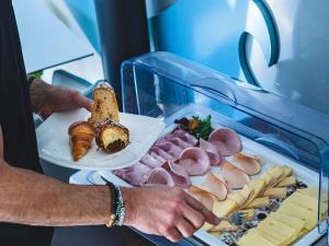 une personne tenant une assiette de charcuterie et de fromage dans l'établissement ibis Styles Strasbourg Avenue du Rhin, à Strasbourg 108 autres photos