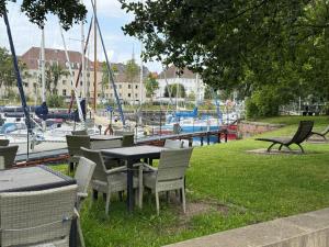 ブレーマーハーフェンにあるZentrales Apartment Yachthafen free parkingのマリーナのある公園にあるテーブルと椅子のグループ +8枚の写真