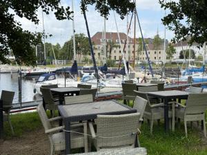 ブレーマーハーフェンにあるZentrales Apartment Yachthafen free parkingのボートのあるマリーナの近くにあるテーブルと椅子のグループ