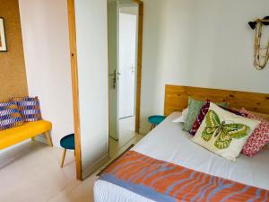 a bedroom with a bed with butterfly pillows and a mirror at Coco bay 2 in Saint-Benoît-des-Ondes