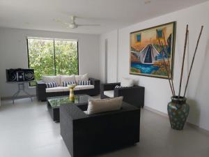 a living room with two couches and a painting at Exclusiva casa campestre in Ricaurte