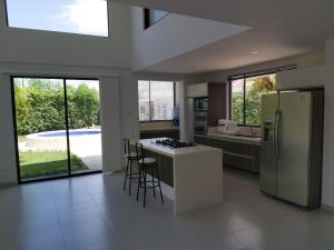 a kitchen with a refrigerator and a counter with stools at Exclusiva casa campestre in Ricaurte