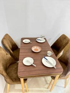 Una mesa de madera con platos y utensilios sobre ella. en Appartement Neuf Plage Mdiq, en M'diq