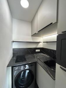 a small kitchen with a washing machine in it at Résidence Chiberta Anglet océan golf surf in Anglet
