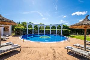 a swimming pool with chairs and an umbrella at Ideal Property Mallorca - Son Manyo 223 in Sa Pobla
