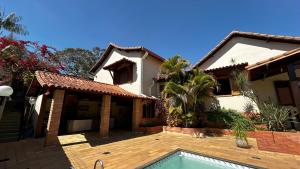 a house with a swimming pool in front of it at Casa Chácara Cambuquira in Cambuquira