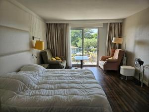 a hotel room with a bed and chairs and a window at Résidence Chiberta Anglet océan golf surf in Anglet