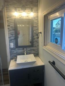 Little Egg Harbor TownshipにあるBeautiful home near LBIの洗面台と鏡と窓のあるバスルーム