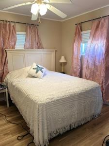 Little Egg Harbor TownshipにあるBeautiful home near LBIのベッドルーム(ピンクのカーテンが付いた白いベッド付)