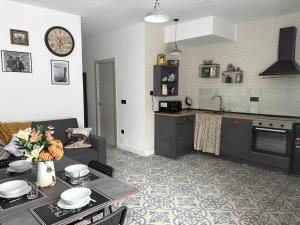 a living room with a table and a kitchen with a clock at Casa 1931 Breakfast Gratis in Valladolid +46 photos