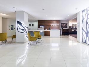 马里扬泊列马里扬泊列美居酒店的大堂设有黄色椅子和柜台