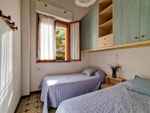 two beds in a small room with a window at Condominio Carina Sud in Bibione