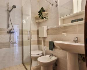 a bathroom with a toilet and a sink and a shower at Condominio Carina Sud in Bibione +67 photos
