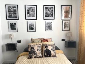 a bedroom with a bed with a bunch of pictures on the wall at Casa 1931 Breakfast Gratis in Valladolid