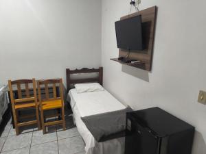 a small room with a bed and a tv at HOTEL TROPICAL in Jardim