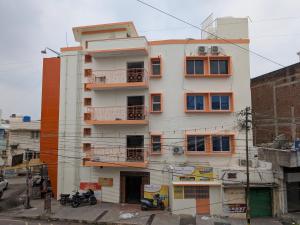 a tall white building with balconies on a street at CM Residency in Salem