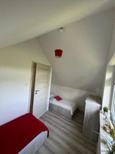 a bedroom with two beds and a red blanket at Domki Ancora - komfortowe domki nad morzem in Jastrzębia Góra