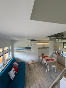 a living room with a blue couch and a table at Domki Ancora - komfortowe domki nad morzem in Jastrzębia Góra
