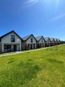 a row of houses with a grass yard at Domki Ancora - komfortowe domki nad morzem in Jastrzębia Góra