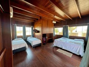 two beds in a room with wooden walls at Pousada Amor Do Arpoador in Tutóia +44 photos