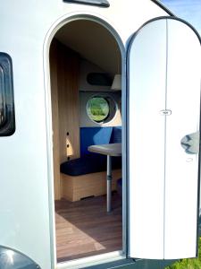 an open door of a camper with a table at Enkel, romslig og kul campingvogn in Moskenes