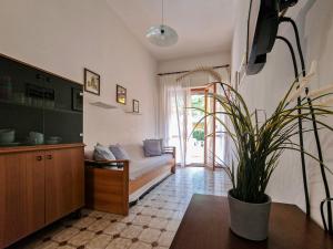 a living room with a couch and a potted plant at Condominio Carina Sud in Bibione