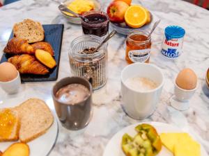 a table with eggs bread and other breakfast foods at Aparthotel Adagio Access Nancy Centre in Nancy