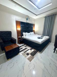 une chambre d'hôtel avec un lit et une chaise dans l'établissement Ventura Hotel & Suites Asaba, à Mama