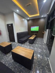 un salon avec un canapé et une télévision à écran plat dans l'établissement Ventura Hotel & Suites Asaba, à Mama 8 autres photos