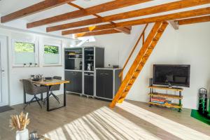 a room with a table and a kitchen with a ladder at Seesicht - Rückzugsort mit Sauna und Freizeitlounge in Wienacht-Tobel