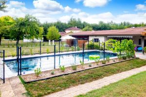 a swimming pool in a yard with a fence at Bed and Breakfast La Villa D'Elejack in Têche