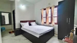 a bedroom with a bed in a room with windows at Jagadeeshwara comforts kalasa in Kalasa +26 photos