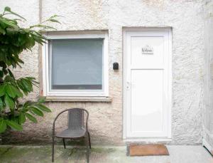 a chair sitting in front of a building with a door at Private Secluded Studio in Sesvete