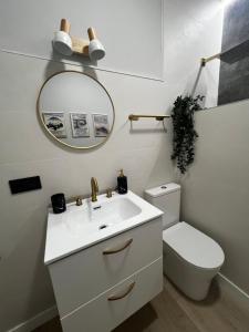 a bathroom with a sink and a toilet and a mirror at La Arquita, tu apartamento en Valladolid in Valladolid +25 photos