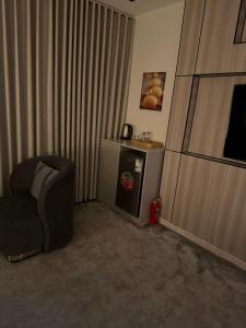 a living room with a chair and a small refrigerator at Cozy Studio in Jeddah +5 photos