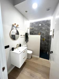 a white bathroom with a sink and a shower at La Arquita, tu apartamento en Valladolid in Valladolid