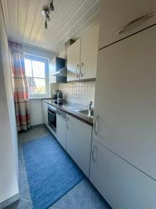 a kitchen with white cabinets and a sink and a window at Apartment Rossleithen 