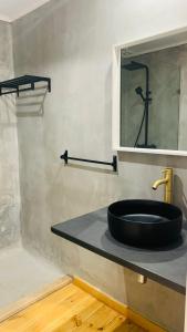 ein Badezimmer mit einem schwarzen Waschbecken und einem Spiegel in der Unterkunft Alma d'Corval in Aldeia do Mato