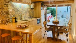 a kitchen with a wooden table and chairs and a dining room at Alma d'Corval in Aldeia do Mato