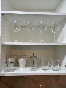 un estante con copas de vino y otros artículos. en Guest apartments The Comfy Nest, en Federal Way