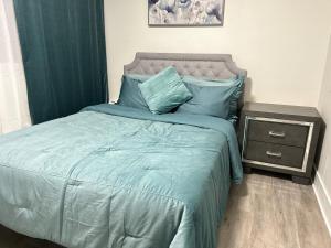 1 cama con edredón azul y mesita de noche en Guest apartments The Comfy Nest, en Federal Way