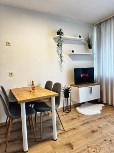 une salle à manger avec une table et des chaises et une télévision dans l'établissement Apartment in Bavorská Ruda, à Bayerisch Eisenstein
