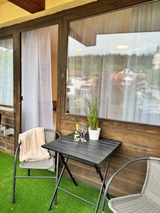 une table et des chaises sur une terrasse avec une fenêtre dans l'établissement Apartment in Bavorská Ruda, à Bayerisch Eisenstein