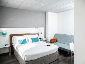 a hotel room with a bed and a couch at Ibis Styles A Coruna in A Coruña