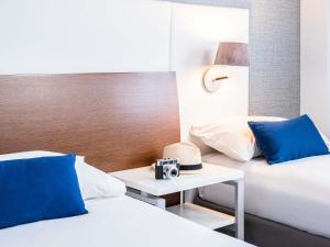 a hotel room with two beds and a camera on a table at Ibis Styles A Coruna in A Coruña +105 photos