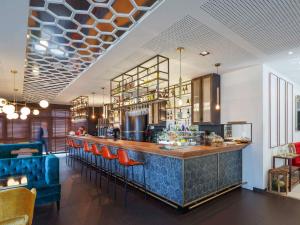 um restaurante com um bar com cadeiras vermelhas em Ibis Styles A Coruna na Corunha