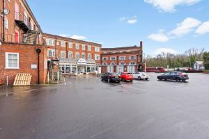 a parking lot with cars parked in front of a building at Bright, airy space with Parking and Netflix Apt 112 in Dudley